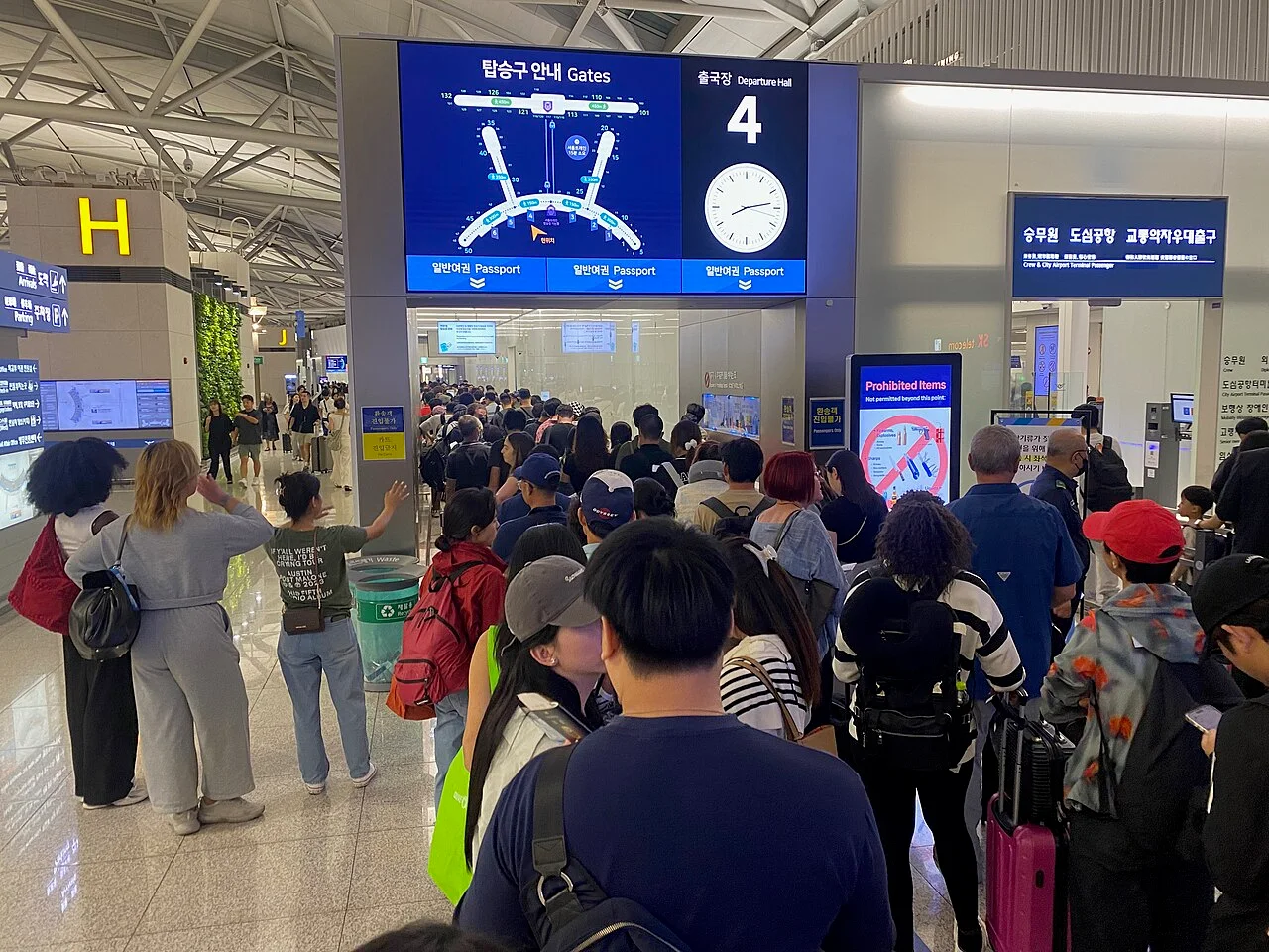 Travelers queuing at a departure entrance in Incheon Airport