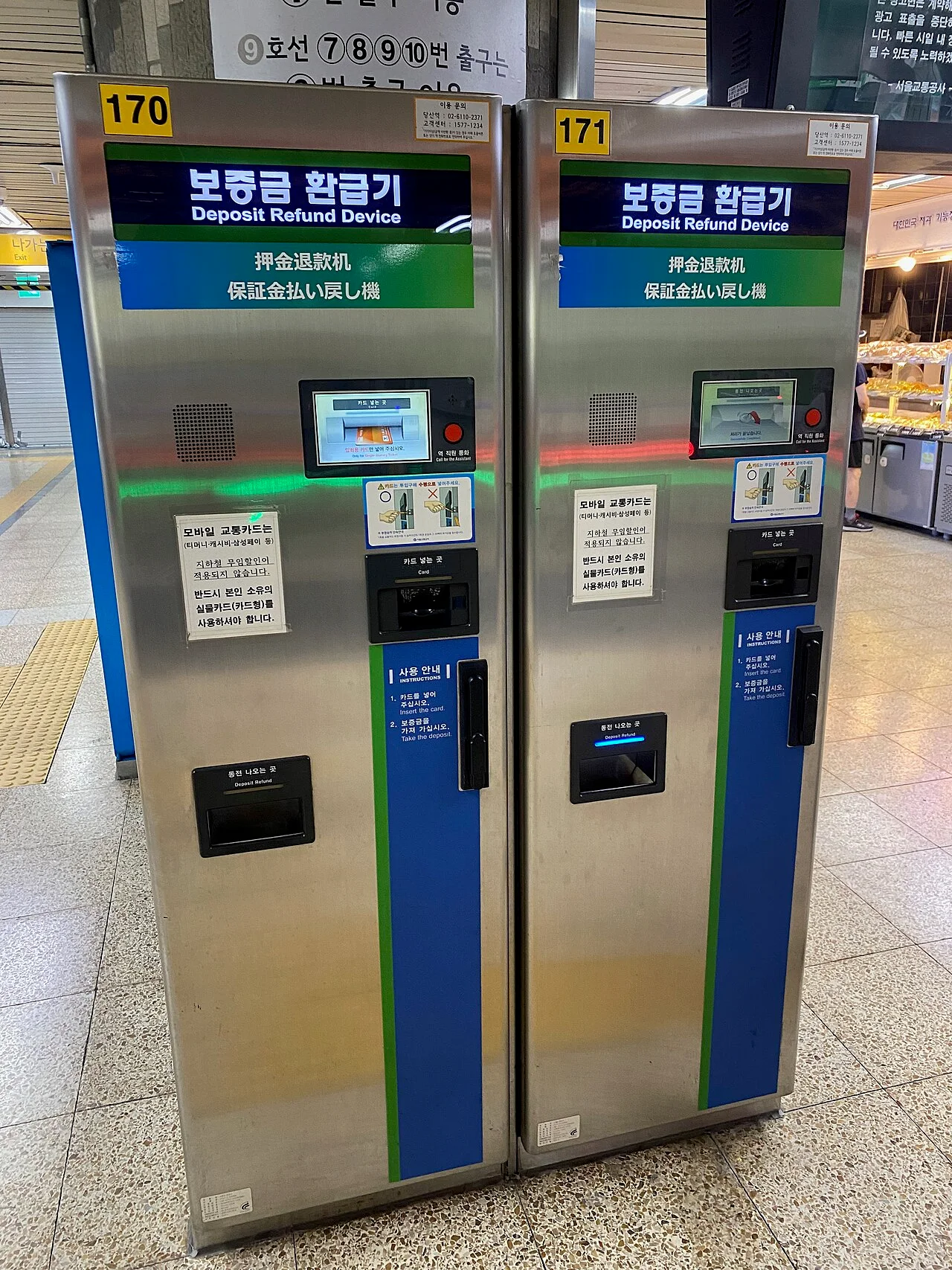 Two deposit refund machines in a Seoul subway station, with a card slot and a coin tray