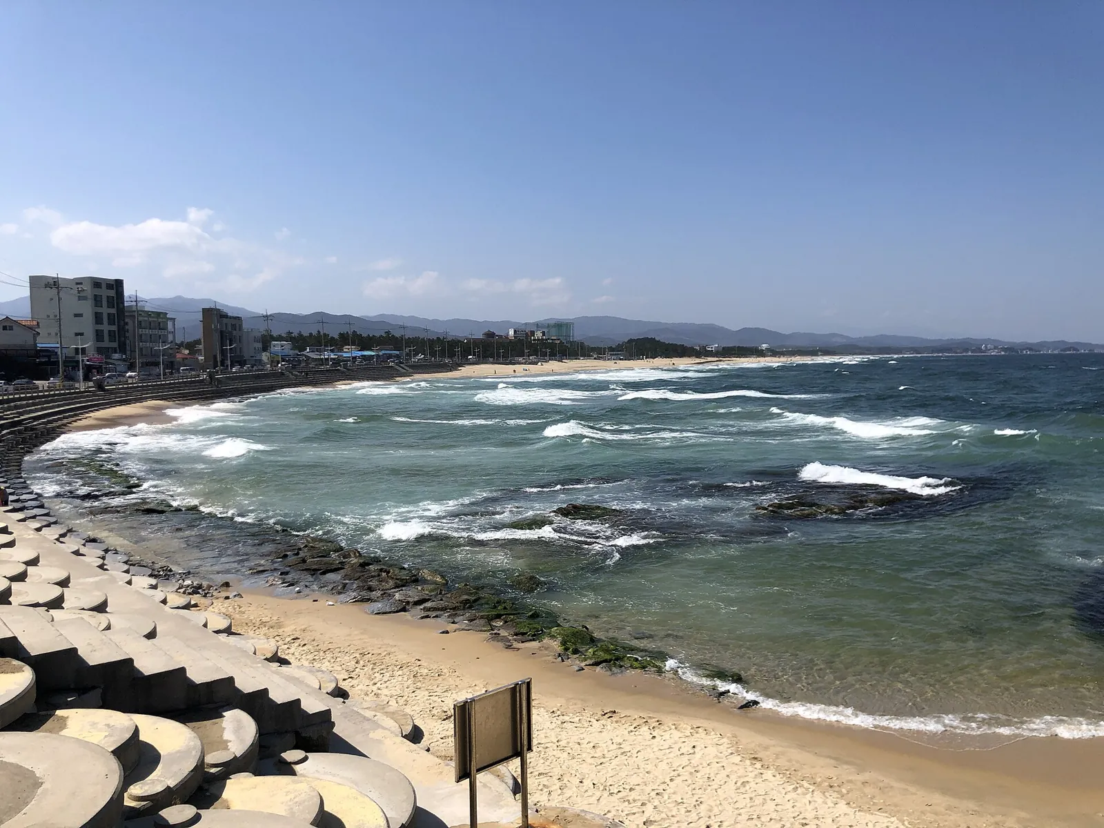 คลื่นซัดเข้าสู่หาดโซดลโดยมีเมืองริมทะเลอยู่ตามแนวชายฝั่งในคังนึง