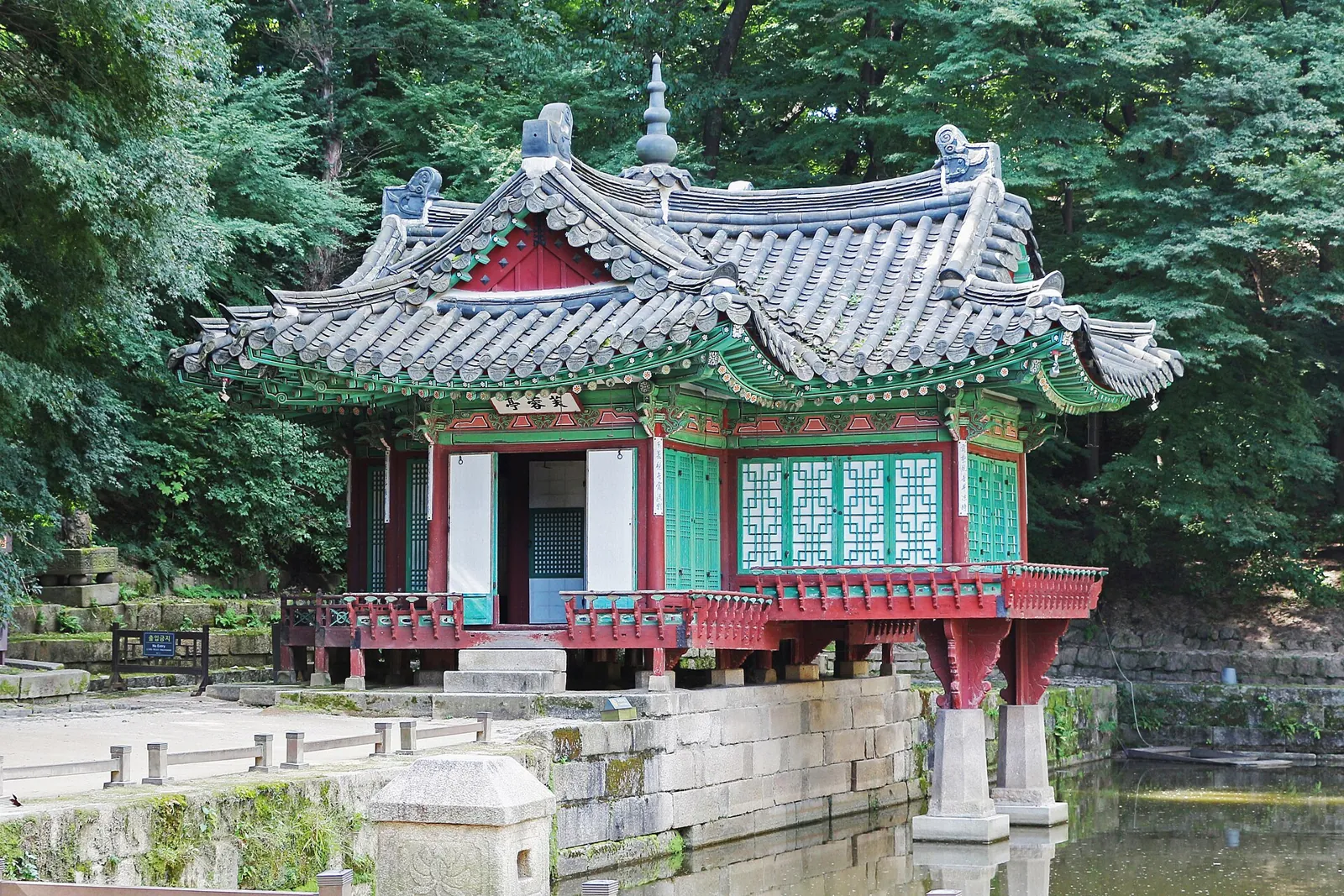 Buyongjeong Pavilion with green and red painted eaves beside a pond in Huwon Garden